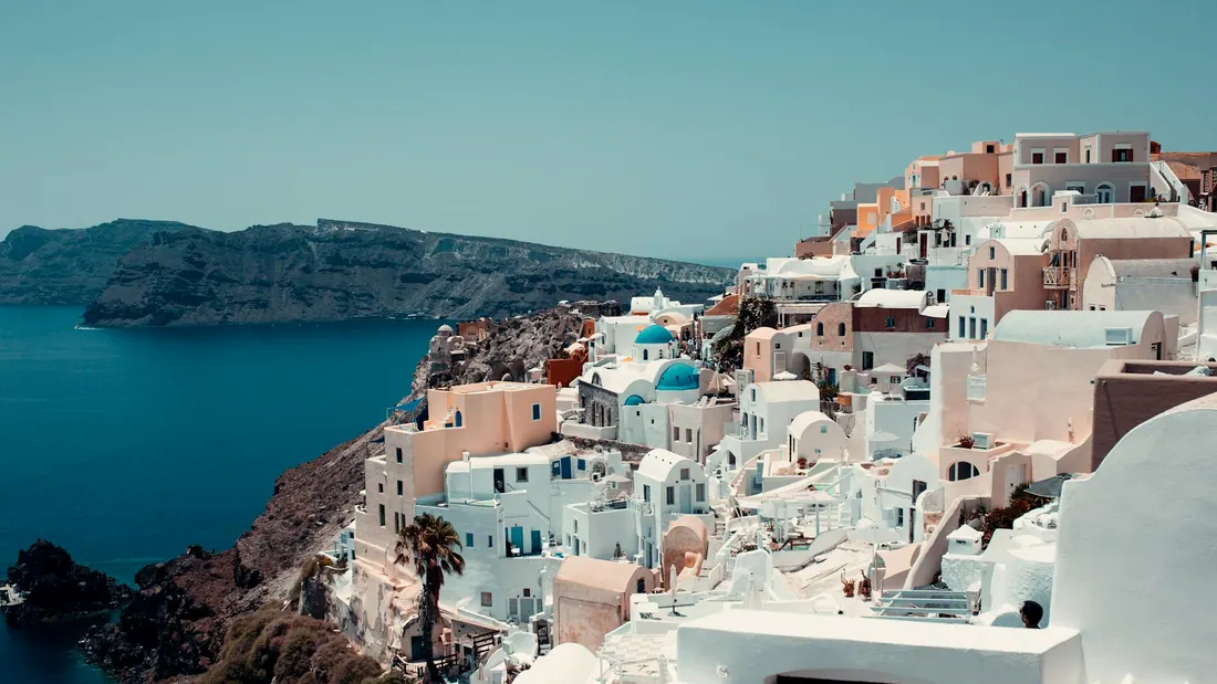 Aerial view of Santorini caldera and white Cycladic buildings — island transfers from Athens